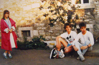 foto von drei jungen menschen, offensichtlich aus den achtzigern, links steht nele in einem leuchtend roten mantel, in der mitte sitzt &bdquo;der p&ouml;hler&ldquo; in sportklamotten, rechts sitzte ich, felix