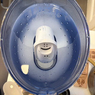 foto eines brita-filters im frischen wasser. die &ouml;ffnungen des filters sehen aus wie ein l&auml;chelnder smiley