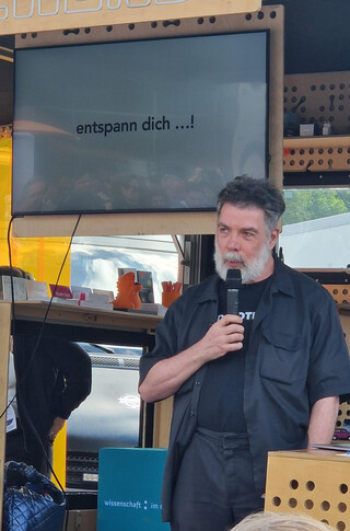auf dem monitor steht: &bdquo;entspann dich...!&ldquo;, ich spreche in ein mikorofon