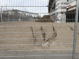 foto von eine, kleinen abhang der von mini-erosionen durchzogen ist, das wasser hat sich den weg zu einem gulli durch den sand gegraben
