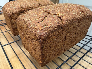 nahaufnahme des fertig gebackenen schwarzbrot. man sieht das es viele k&ouml;rner enth&auml;lt, die kruste ist oben leicht aufgebrochen