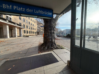 bild vom u-bahn-ausgang des platz der luftbr&uuml;cke. es begr&uuml;sst einen ein alter knorriger baum.