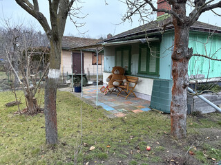 ein entspannter teddyb&auml;r sitzt vor einer gartenaube