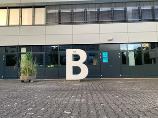 bild grossen beton-B an der  berliner hochschule f&uuml;r technik. oben am B ist einen banane angeklebt.